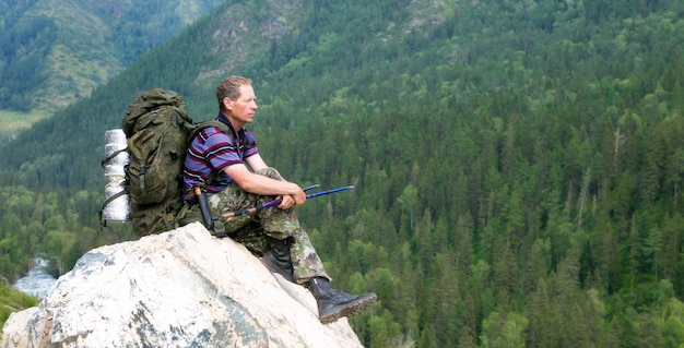 Un turista in alta montagna guarda la natura.