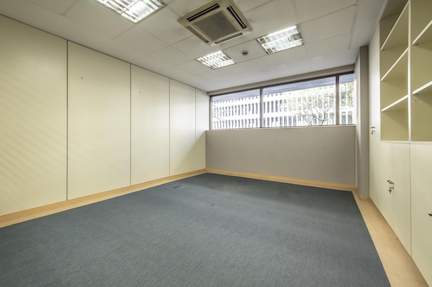 Un ufficio vuoto con pavimenti in moquette blu e schedari con porte chiudibili a chiave