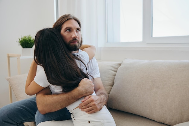 Un uomo abbraccia la sua amica asiatica a casa Supporto psicologico per un amico