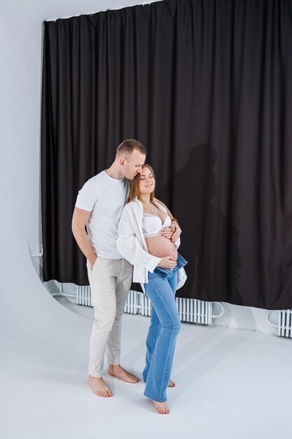 Un uomo abbraccia una donna incinta e le accarezza la pancia una giovane coppia felice è incinta