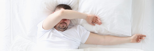 Un uomo adulto dorme in camera da letto su un letto grande concetto di uomo non iniziato