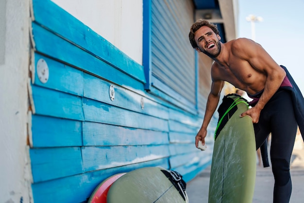 Un uomo allegro che prepara la tavola da surf