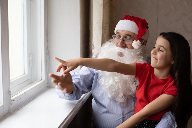 un uomo anziano con un cappello da Babbo Natale e una nipote