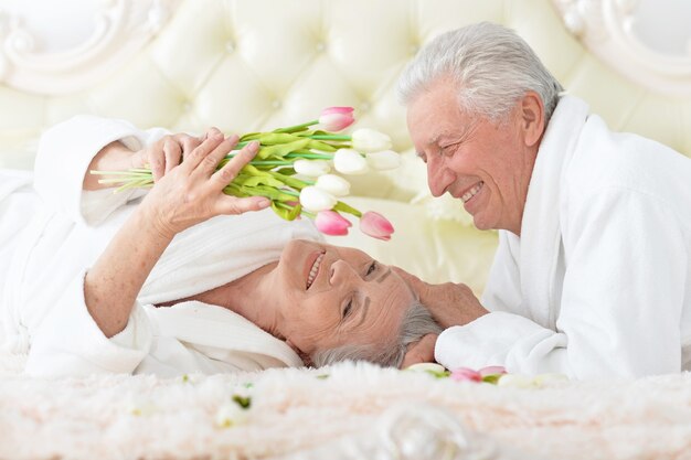 Un uomo anziano felice regala fiori a una donna