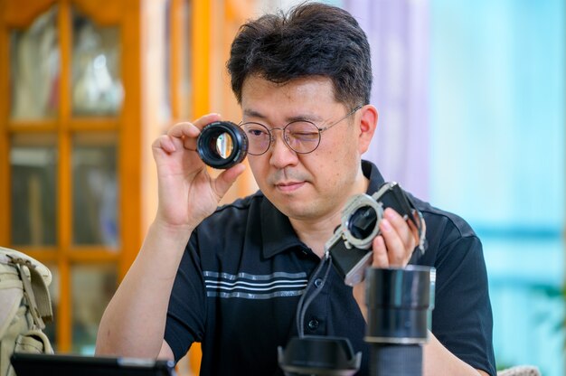 Un uomo asiatico di mezza età il cui hobby è la fotocamera SLR con pellicola da 35 mm / 135 mm