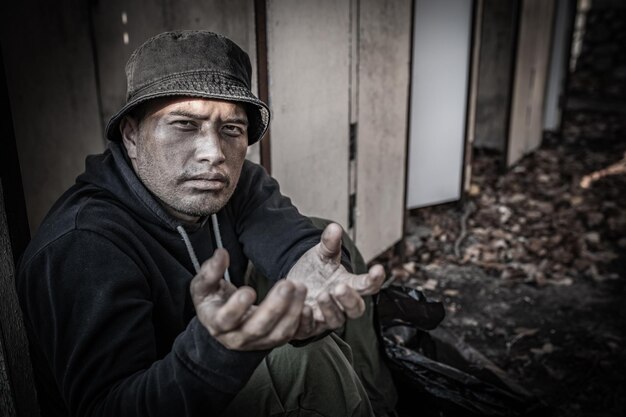 Un uomo asiatico è un senzatetto lungo la strada. Uno straniero deve vivere da solo per strada perché non ha famiglia