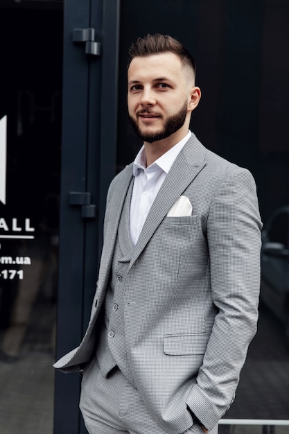 Un uomo barbuto con la barba rossa in camicia, gilet e occhiali.