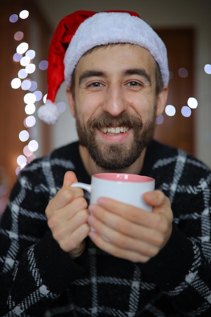 Un uomo barbuto con un cappello di Babbo Natale L'uomo sorride e si gode il ritratto del primo piano di Capodanno