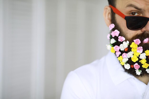 Un uomo barbuto con una barba decorata per le vacanze di primavera Fiori nella barba