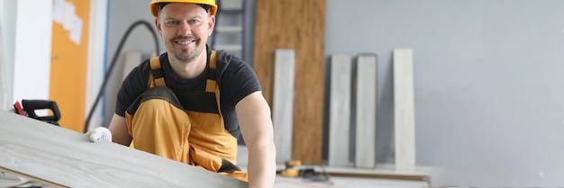 Un uomo cambia tra le mani il laminato del rivestimento del pavimento