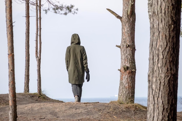 Un uomo cammina lungo il bordo di una duna sulla riva del Mar Baltico