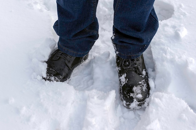 Un uomo cammina nel cumulo di neve innevato