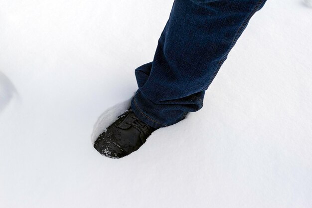 Un uomo cammina nel cumulo di neve innevato