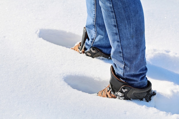 Un uomo cammina nella neve, impronte nella neve, neve profonda, cumulo di neve.