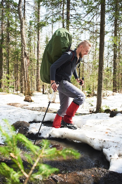 Un uomo che attraversa un ruscello in una foresta