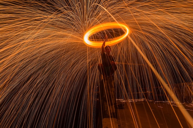 Un uomo che fa girare un anello di scintille di fuoco.