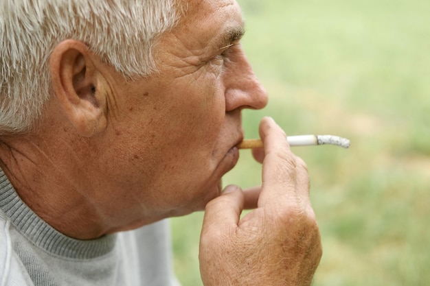 un uomo che fuma una sigaretta con una sigaretta in bocca.