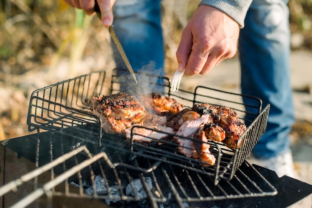 Un uomo che griglia una bistecca su una griglia per barbecue