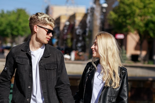 Un uomo che indossa occhiali da sole e guarda la sua ragazza al parco Foto di alta qualità