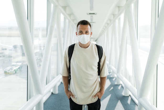 Un uomo che indossa una maschera durante una pandemia in aeroporto