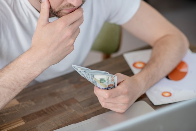 Un uomo che lavora seduto al laptop e sembra frustrato