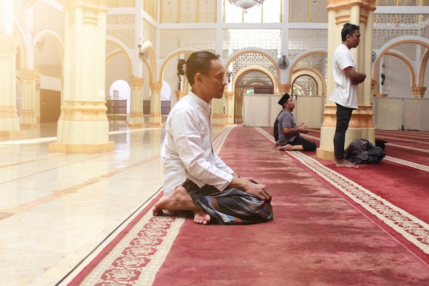 Un uomo che medita in una moschea con un cartello che dice "la parola preghiera".