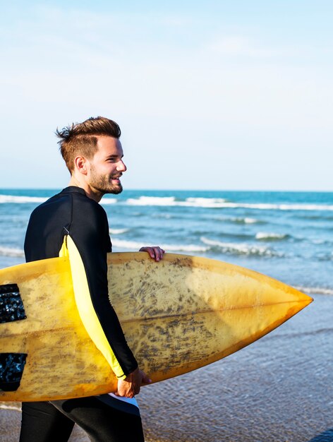 Un uomo che porta una tavola da surf