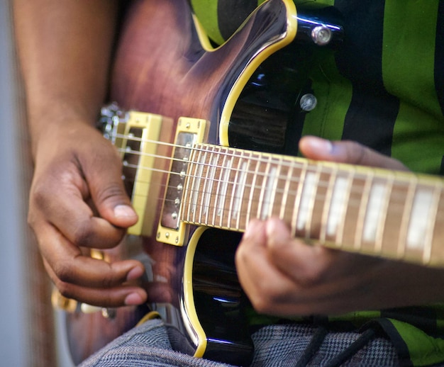 Un uomo che suona una chitarra con una maglietta verde e gialla.