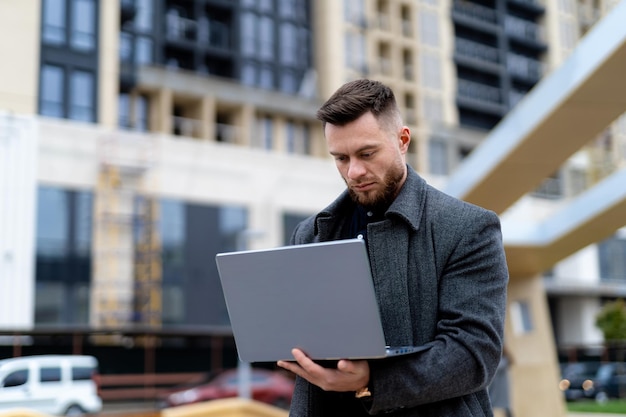 Un uomo che tiene in mano un computer portatile