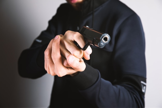 Un uomo che tiene in mano una pistola nera minacciosa