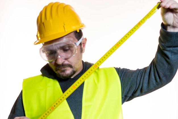 un uomo che vuole fare un lavoro senza conoscenza, un lavoro senza esperienza. Fai da te, uomo vestito con un casco da costruttore giallo con occhiali protettivi pronto per iniziare i lavori di costruzione