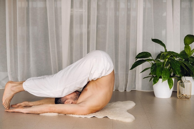 Un uomo con il torso nudo fa yoga in una sala fitness il concetto di uno stile di vita sano