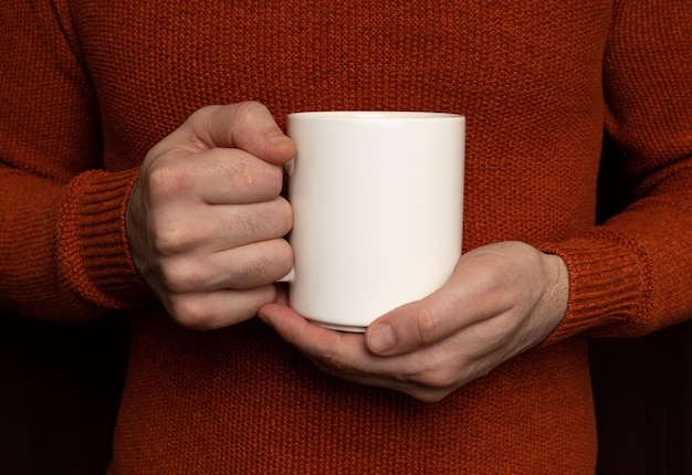 Un uomo con in mano una tazza bianca con sopra la parola caffè