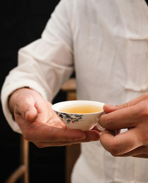 Un uomo con in mano una tazza di tè verde