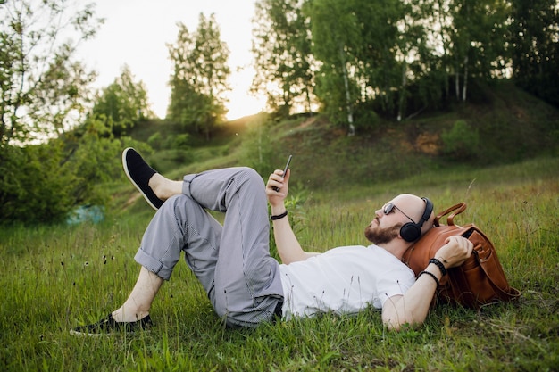 un uomo con la barba che ascolta la musica nel parco