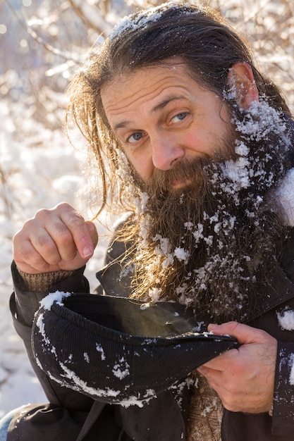 Un uomo con la barba nella neve.