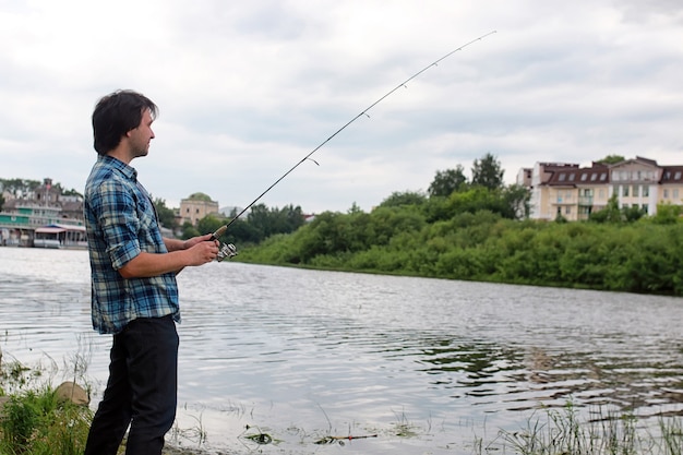 Un uomo con la barba sta pescando per la filatura nel fiume