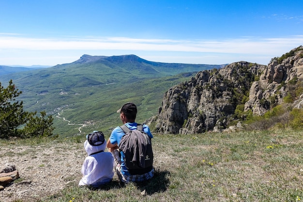 Un uomo con un bambino sullo sfondo dell'altopiano di ChatyrDag dal Monte Demerji in Crimea Russia