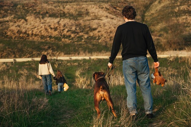 un uomo con un cane guarda sua moglie e sua figlia lasciarlo