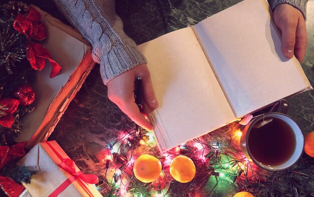 Un uomo con un libro bianco in mano per la tavola di Capodanno con decorazioni