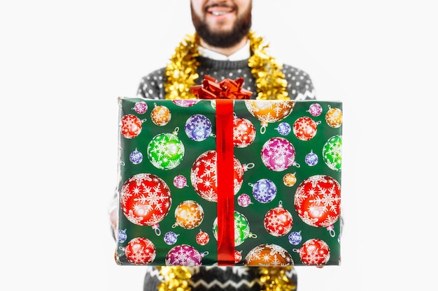 Un uomo con un regalo di Natale in mano in Studio su uno sfondo bianco regalo closeup