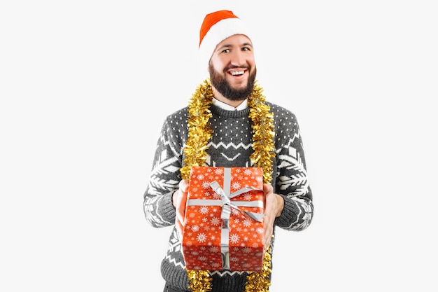 Un uomo con un regalo di Natale in mano in Studio su uno sfondo bianco