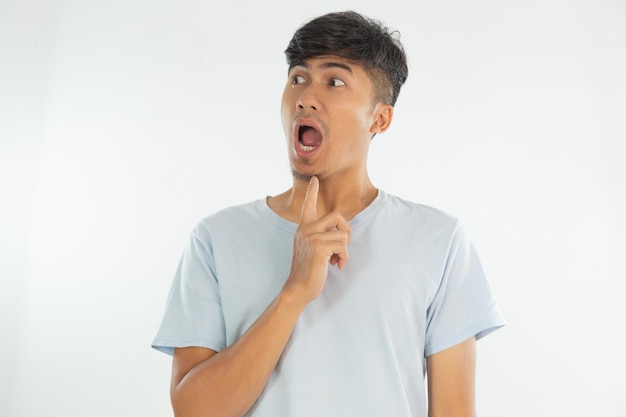 Un uomo con una camicia blu sta alzando lo sguardo e ha un dito sul mento.