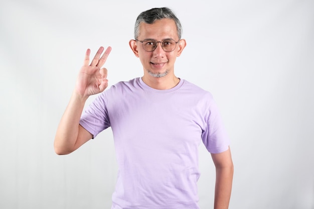 Un uomo con una camicia viola sta facendo segno ok con le dita