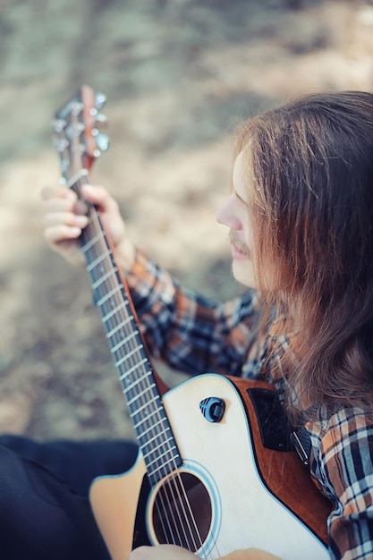 Un uomo con una chitarra in una giornata estiva all'aperto