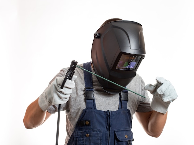 Un uomo con una maschera da saldatura, vestiti e guanti robotici, che tiene in mano un filo con un elettrodo di saldatura.