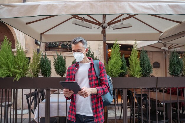 Un uomo con una maschera protettiva che cerca un posto con il gps