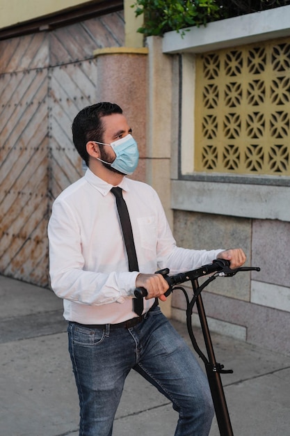 Un uomo con una maschera protettiva e uno scooter in strada