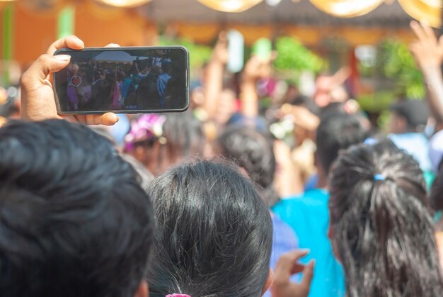 Un uomo con uno smartphone in mano che spara alla gente birmana