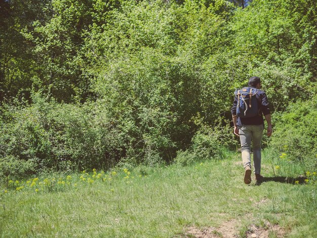 Un uomo con uno zaino in escursione nella natura